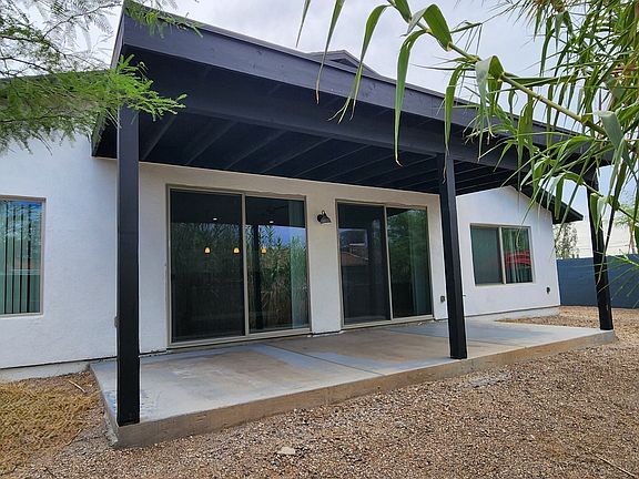 Rear elevation and private, fenced in backyard. Covered concrete patio.