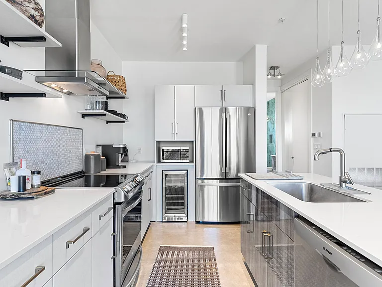 This fully equipped kitchen features high-end appliances, a wine cooler, and custom cabinetry.