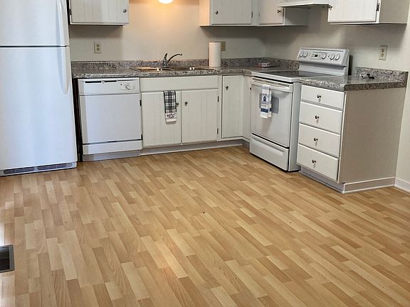 Spacious kitchen with stove, dishwasher and refrigerator.