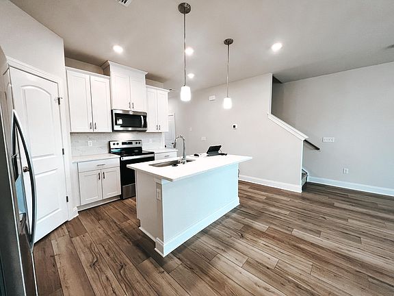 Kitchen with large island for entertaining, upgraded backsplash and appliances, and walk in pantry.