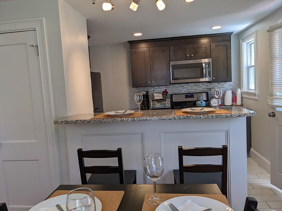Bright Kitchen w/ newer cabinets, granite counters& breakfast bar, tiled floor & backsplash plus dishwasher & gas stove