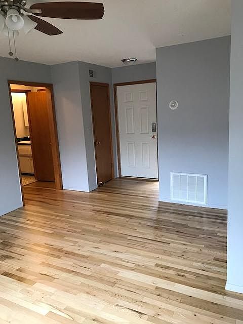 Large living area with coat closet, central heating and air, original hardwood floors.