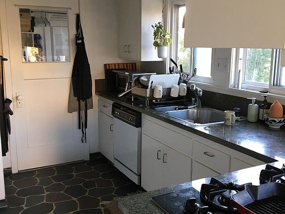 Kitchen with modern amenities, including double sink, garbage, disposal, dishwasher, double ovens and a gas cooktop with a nice hill view and morning sun