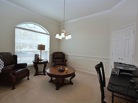Living or Dining Room, your choice  with high ceilings, chair rails and crown molding and french doors leading into kitchen.