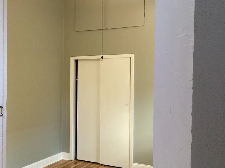 Bedroom with closet and a storage unit above.