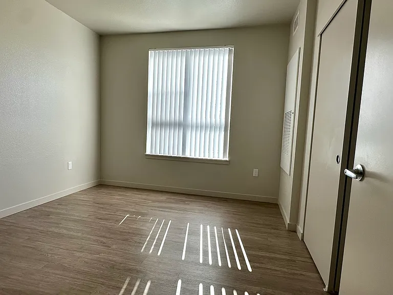 One-Bedroom unit with oversized window and full closet with sliding doors.