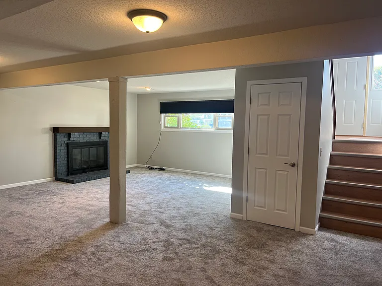 Lower level family room with wood burning fireplace. New carpeting. Large storage room and laundry off of family room