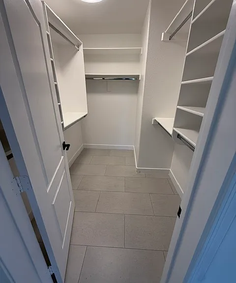 Huge walk in closet with great lighting and tile throughout