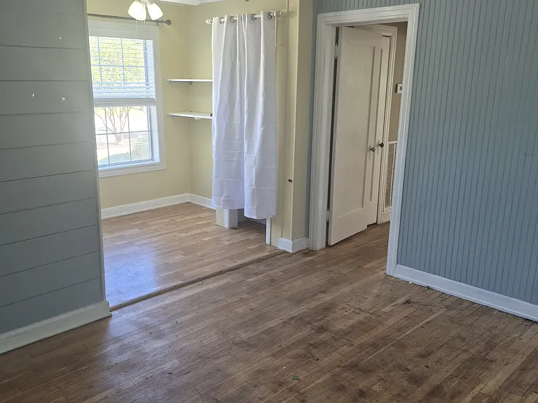 Living room from front door. Dining area and pantry to the left, hall to bedroom on the right.