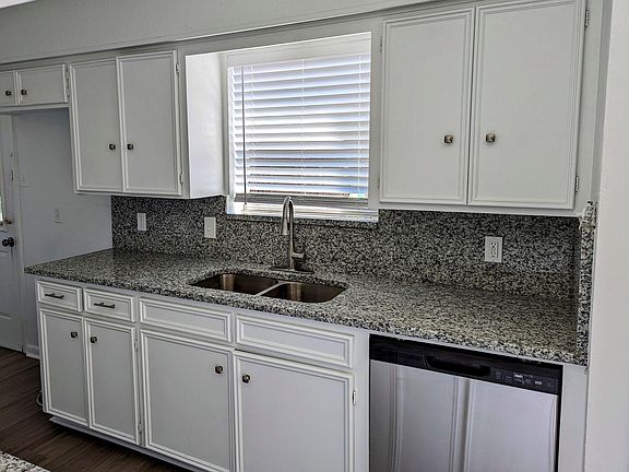 Galley kitchen with new dishwasher and stainless steel sink.