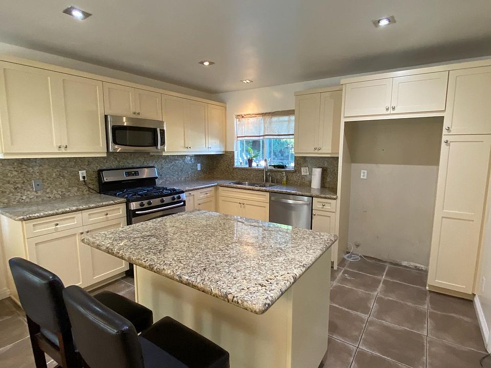 Updated kitchen offering plenty of cabinet space, granite counter tops and stainless steel gas stove, dishwasher and microwave.