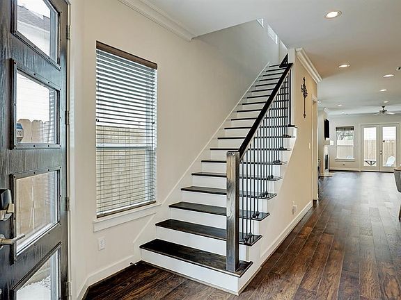 The entry of the home is very inviting and warm. A wrought iron banister with wood hand rails and wood stairs lead to the second floor. The flooring is 6.5 inches wide wood planks throughout the entire home!