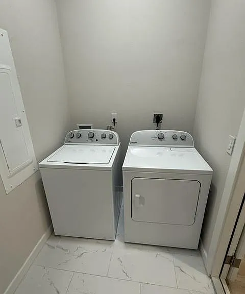 Dedicated laundry nook with side-by-side washer and dryer, convenient hookups, and easy-clean tile flooring.