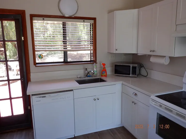 kitchen with updated dishwasher, stove, refrigerator, sink, cabinets and countertop