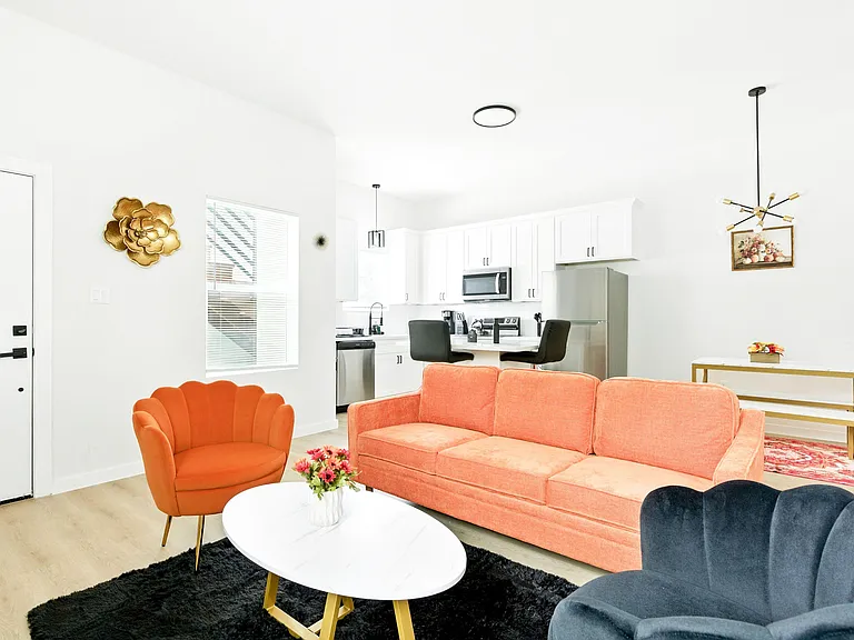 Open-concept living area with comfortable seating, adjacent breakfast bar, and a well-equipped kitchen with stainless applian