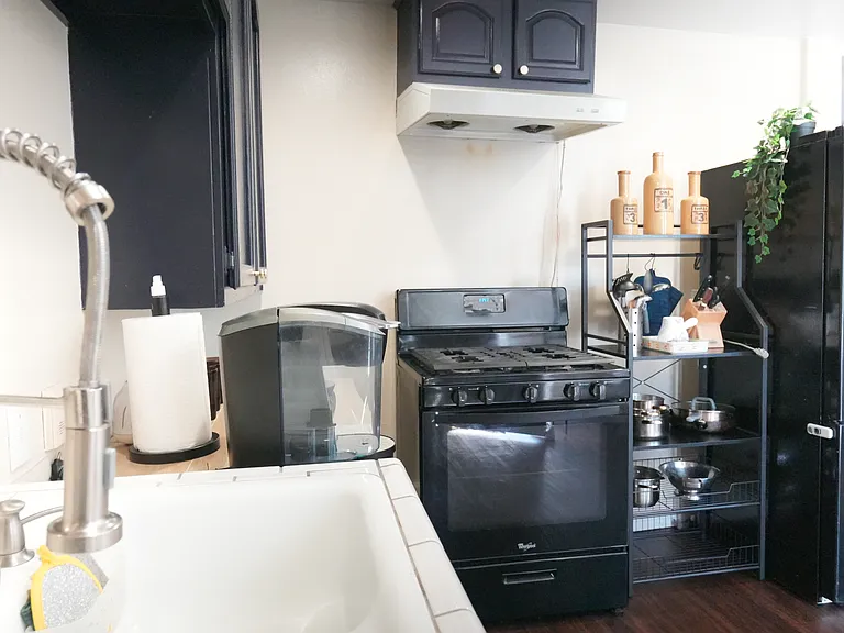 Full size kitchen includes refrigerator, stovetop, and a barn-style kitchen sink