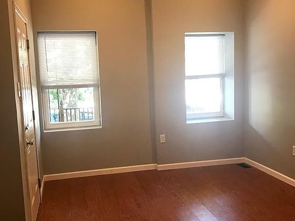 Living room with new floors - well lit with windows overlooking front porch.