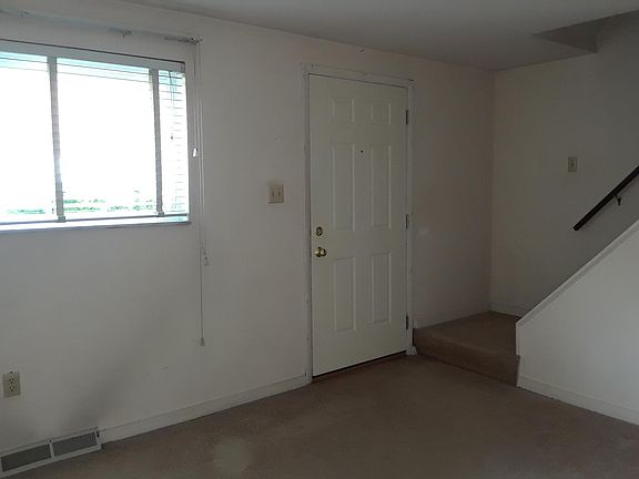 Large, bright living room with front door entrance
