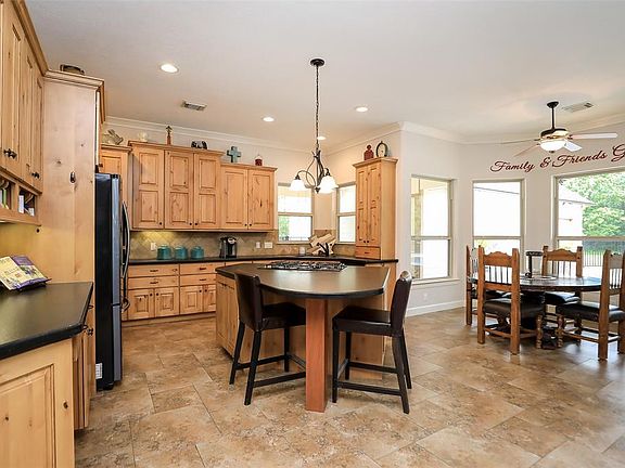 Large kitchen and Island, 2 pantries, tons of custom cabinetry "knotty Alder" wood, Honed black granite, island has gas cook top with down draft! Huge picture window overlook pool area