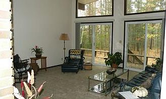 Another view of the living room.br /Great views out the newer sliding glass doors, to the beautifully wooded land.