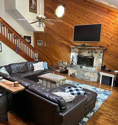 Extra large living room with wood burning fireplace and vaulted ceilings.