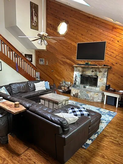Extra large living room with wood burning fireplace and vaulted ceilings.