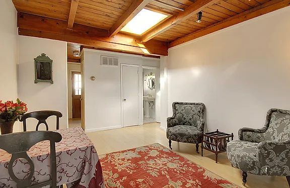 Living room/dining room area showing entrance to kitchen on the left and bathroom on the right
