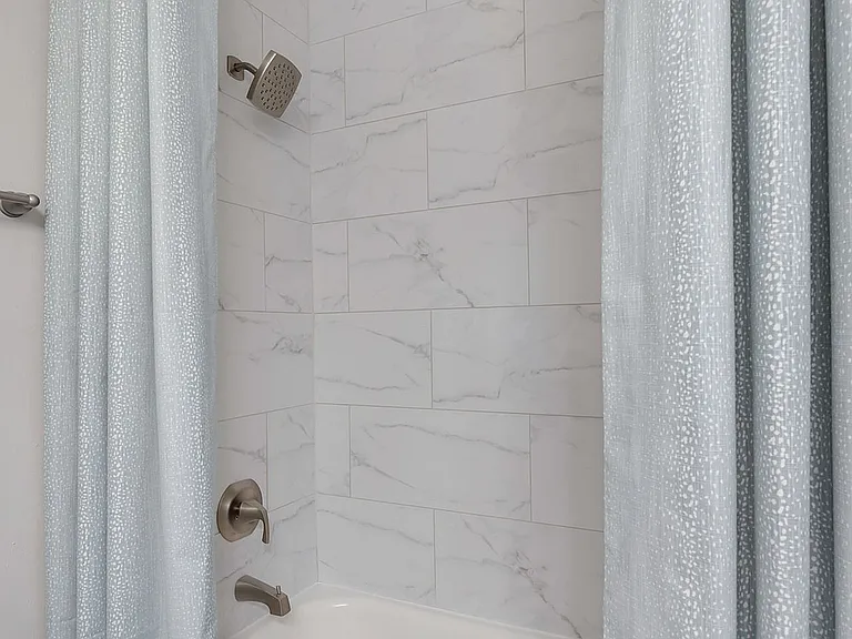 Bright bathroom with bathtub and marble backsplash