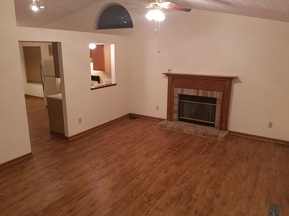 Great room with fireplace and vaulted ceiling overlooking kitchen area