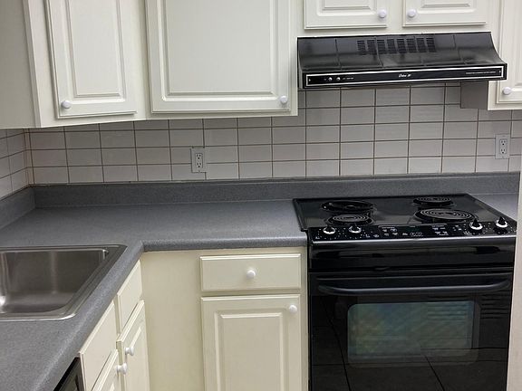 The kitchen serves as the heart of the home, offering plenty of workspace, ample cabinetry, and a pass-through window that keeps you connected to the dining and living areas.