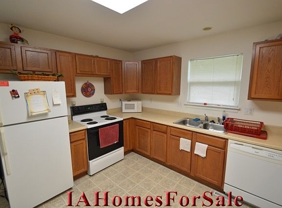 Well-lit kitchen furnished with refrigerator, stove and dishwasher included with purchase.