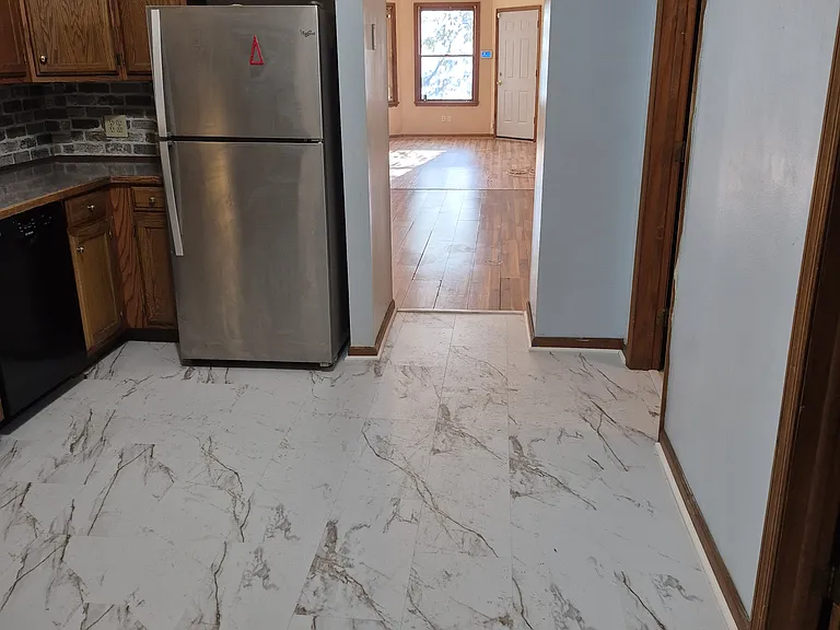 Full length view from back door through kitchen, dining and living rooms to front door