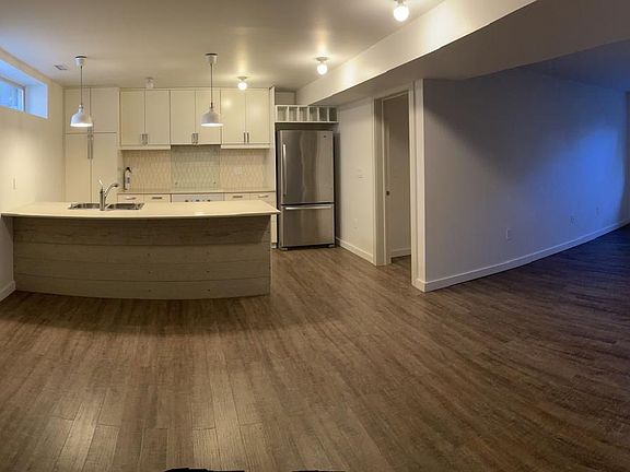 Open kitchen/living room/dining room space with a bedroom to the left and to the right. Modern fixtures throughout. Central AC.