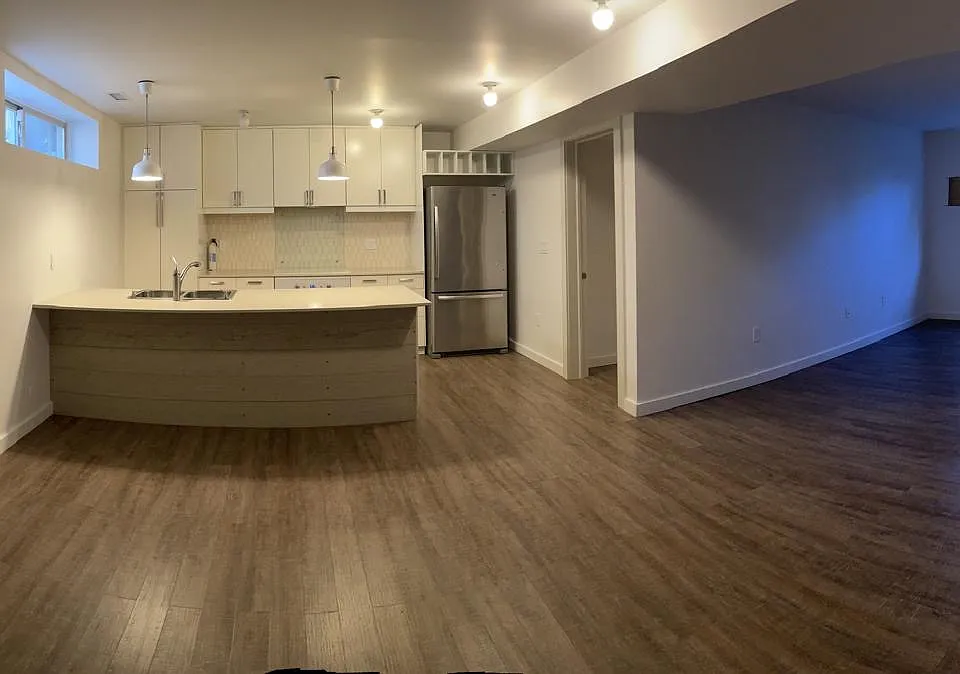 Open kitchen/living room/dining room space with a bedroom to the left and to the right. Modern fixtures throughout. Central AC.