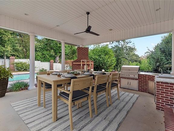 Upon entering you are greeted by a grand Foyer adorned with an exquisite chandelier and a sweeping staircase, setting the tone for the rest of the home. The spacious living areas are bathed in natural light , enhancing the beauty of the rich hardwood floors and elegant high ceilings and crown molding throughout.