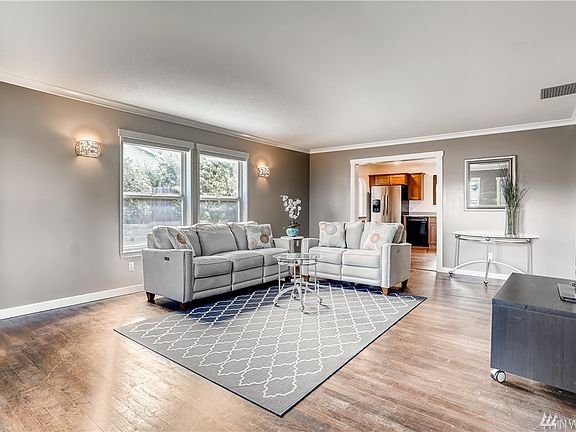 Spacious living room with fresh neutral interior tones, new white trims, vinyl windows and all newer exterior doors throughout home.