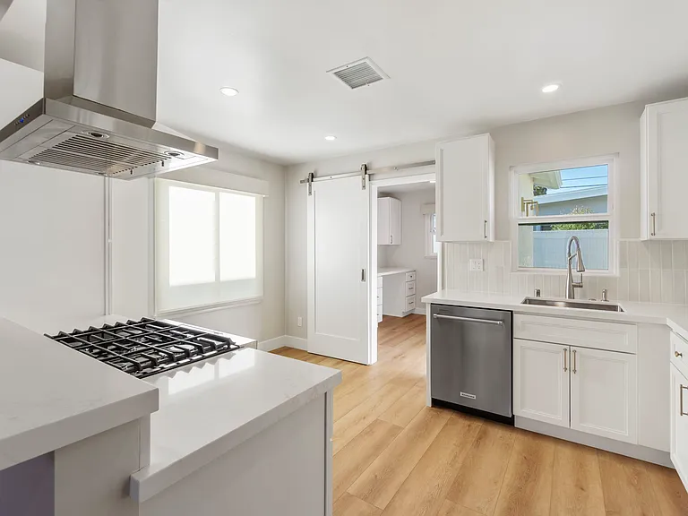 Kitchen opens up to large laundry room and office space with barn door enclosure