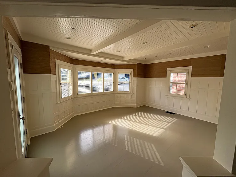 Living room view. Wood floors and wooden shades