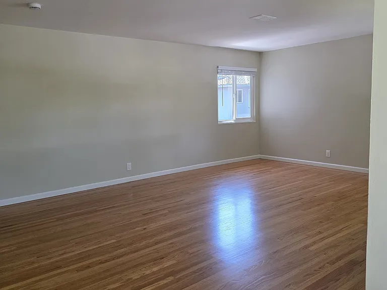 View of the living room standing at the large floor to ceiling windows.