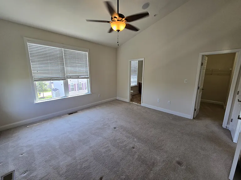 Third floor primary suite with entrance to full bath on left and entrance to walk in closet on right.