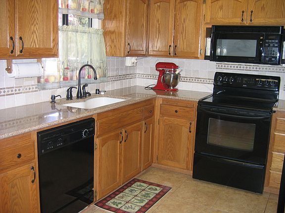 New engineered stone countertops with tumbled marble splash, Kohler sink