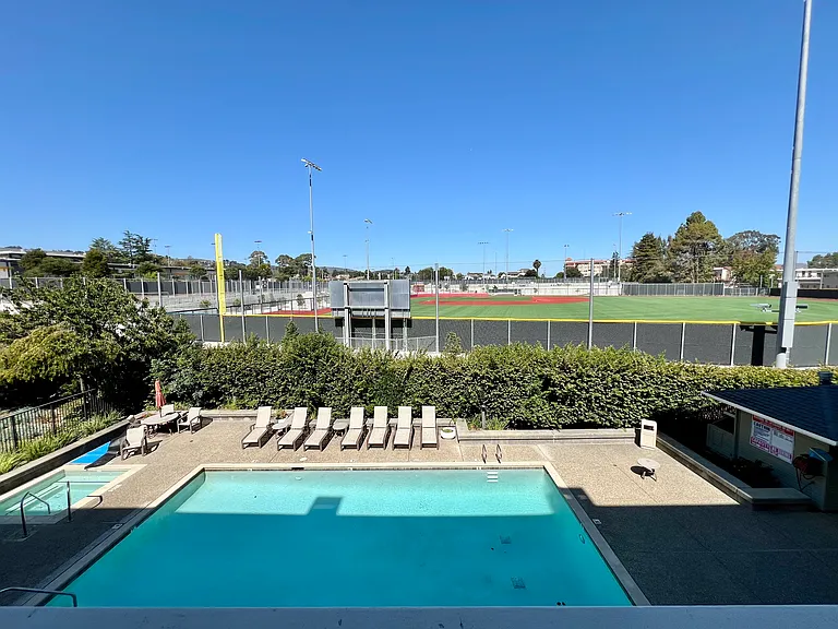 Balcony view: pool, field.