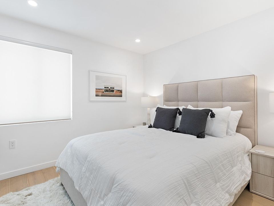 Wind down in the downstairs guest bedroom, featuring a large bed and clean design.