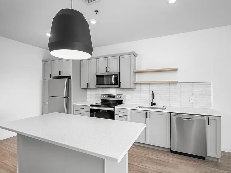 Modern kitchen with sleek stainless steel appliances, minimalist cabinetry, and a spacious central island under elegant lighting. Modern kitchen with sleek stainless steel appliances, minimalist cabinetry, and a spacious central island under elegant light