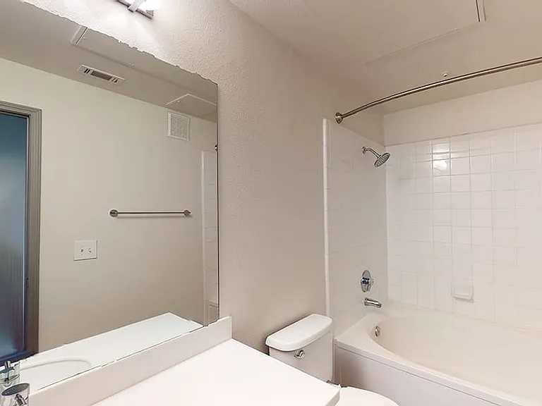 Apartment bathroom with wood-style flooring.