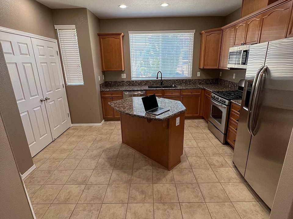 From dining area looking into kitchen. Refridgerator, gas stove, microwave & dishwasher. Pantry on left.