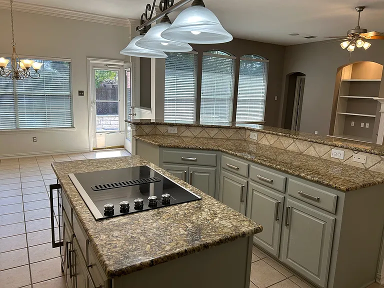 Kitchen with granite countertops and electric cooktop.