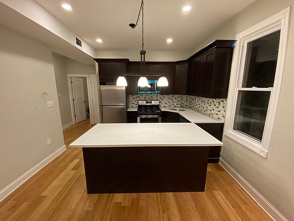 Front view of contemporary kitchen cabinetry, brand new stainless steel appliances with quartz counter tops