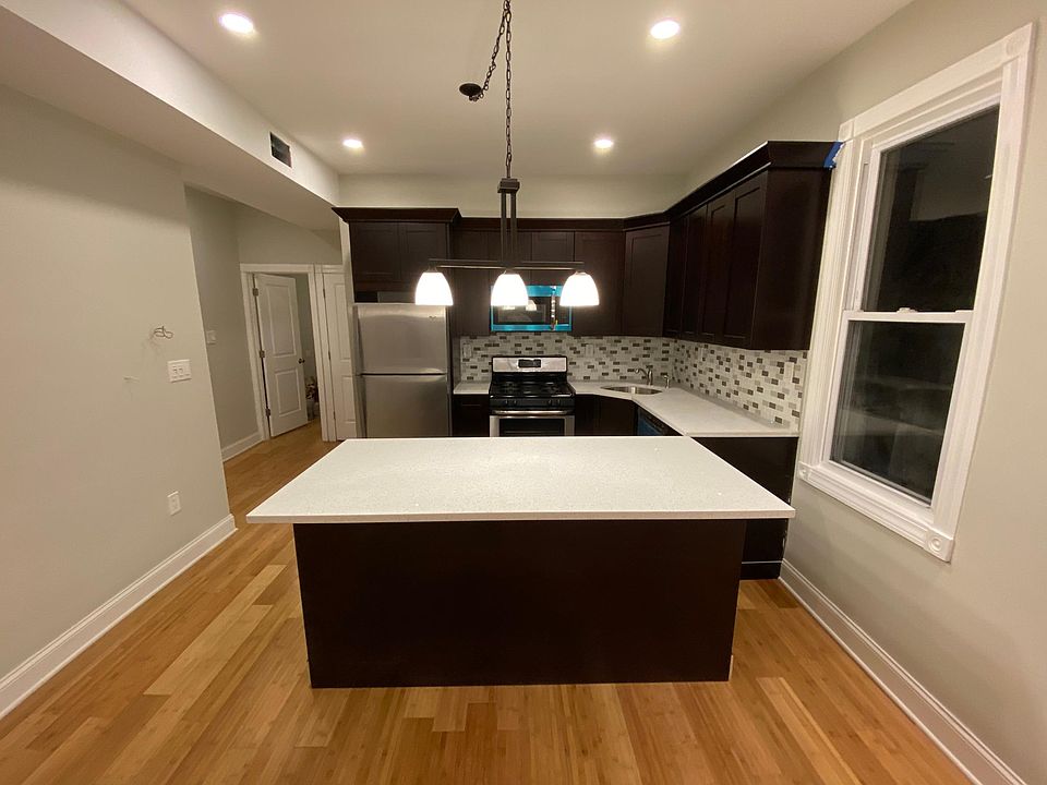 Front view of contemporary kitchen cabinetry, brand new stainless steel appliances with quartz counter tops