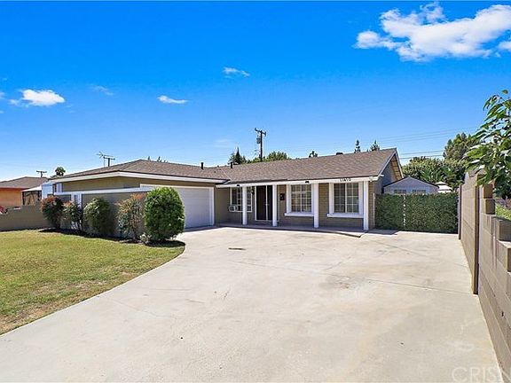 Front of house with view of large driveway